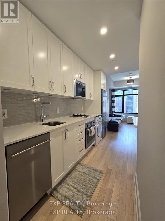 A kitchen with white cabinets and a stainless steel dishwasher.