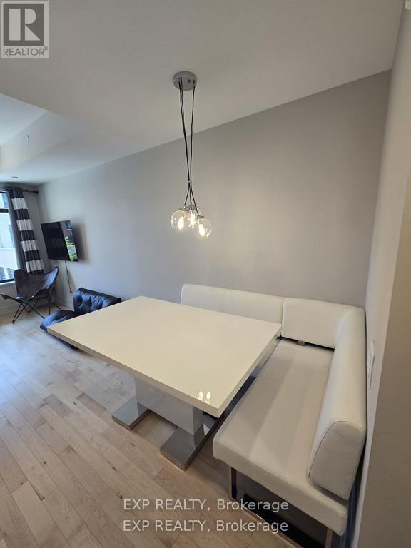 A modern dining room with a white table and chairs.