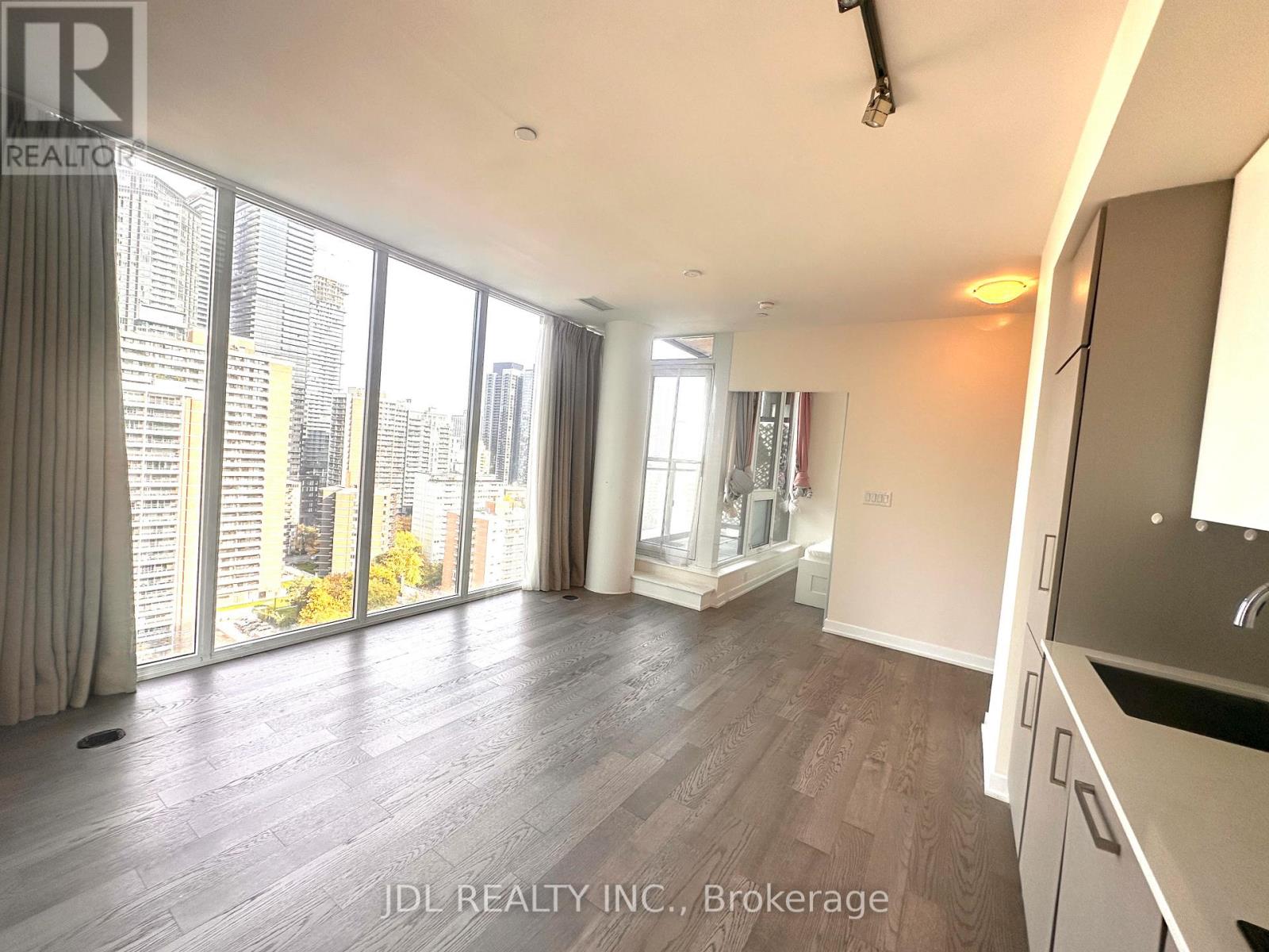 A spacious living room with a view of the cityscape outside the large windows.