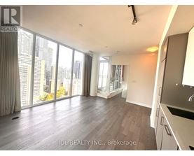 A spacious living room with a view of the cityscape outside the large windows.