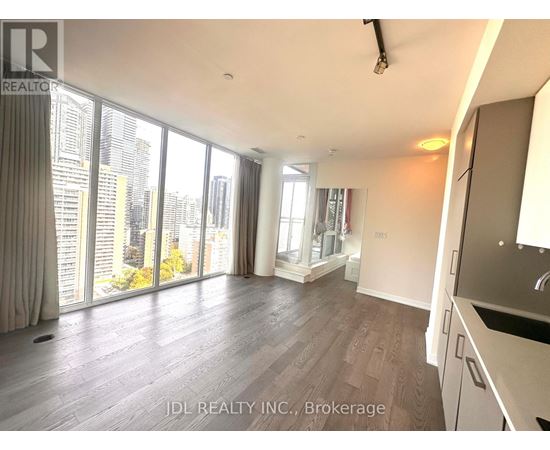 A spacious living room with a view of the cityscape outside the large windows.