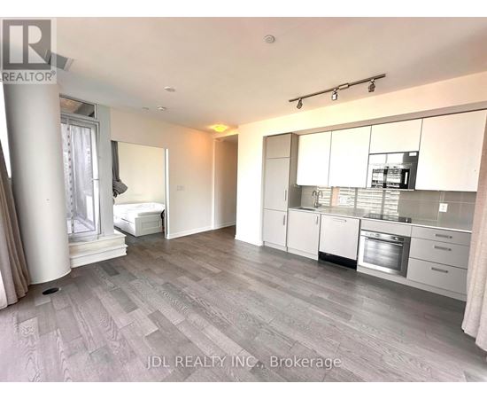 A spacious kitchen with white cabinets and a grey floor.