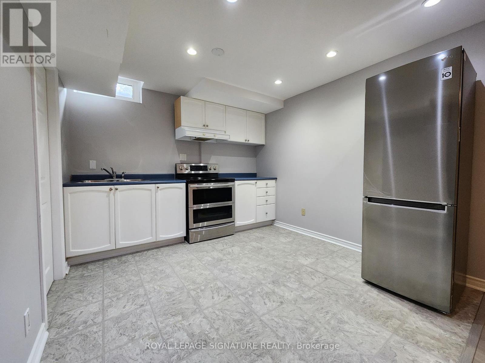 A kitchen with a refrigerator on the right side.