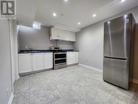 A kitchen with a refrigerator on the right side.