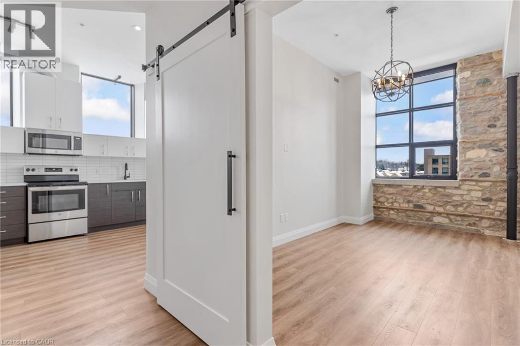 A modern kitchen with a white fridge and wooden floors.