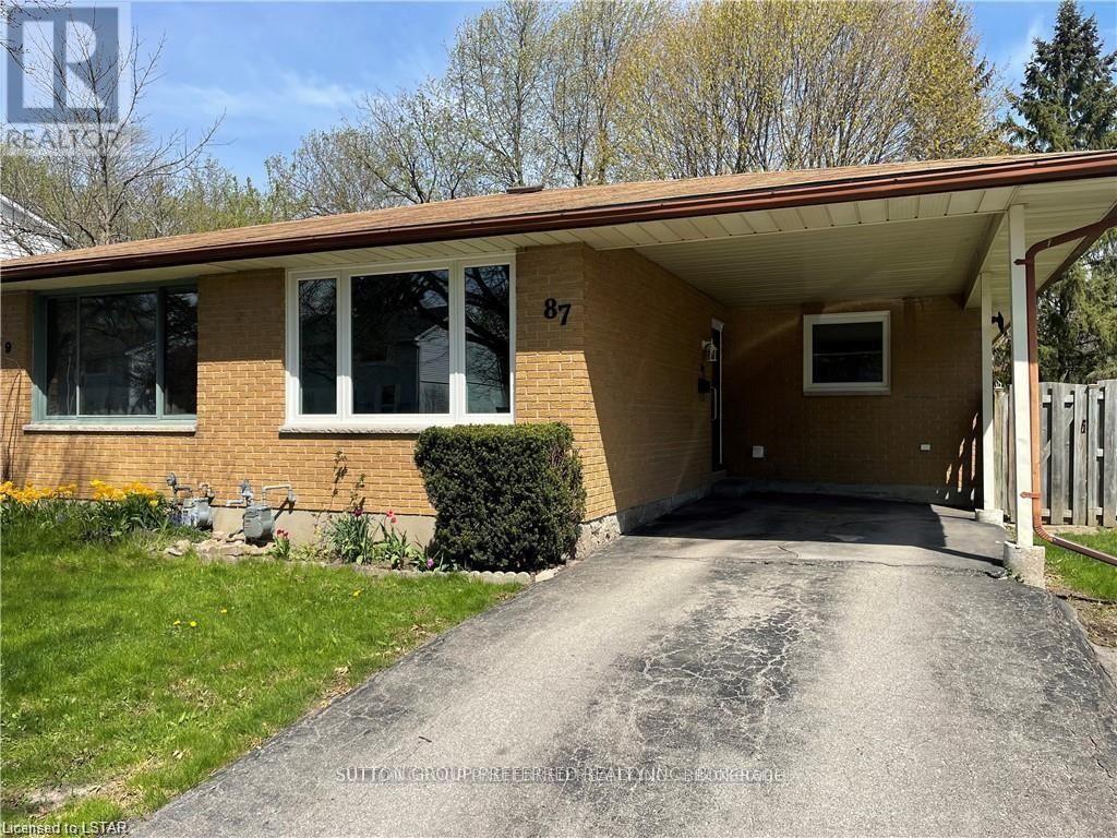 A house numbered 87 with a driveway leading to the front door.