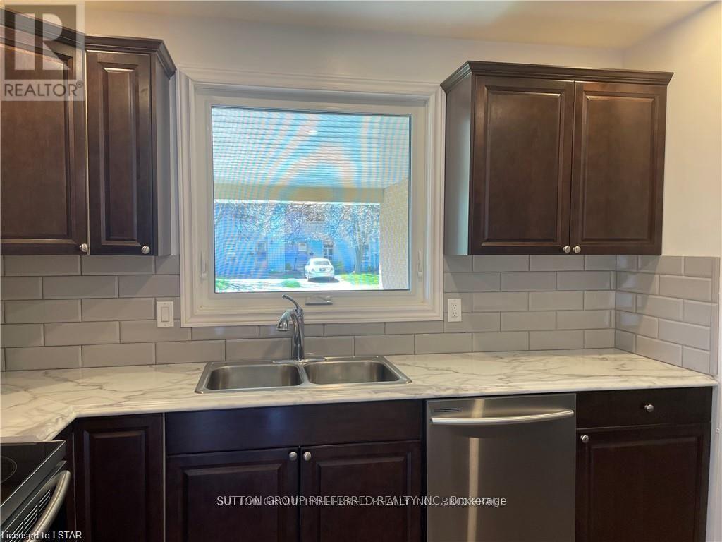 A kitchen with dark brown cabinets and a white countertop.