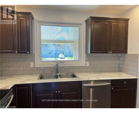 A kitchen with dark brown cabinets and a white countertop.