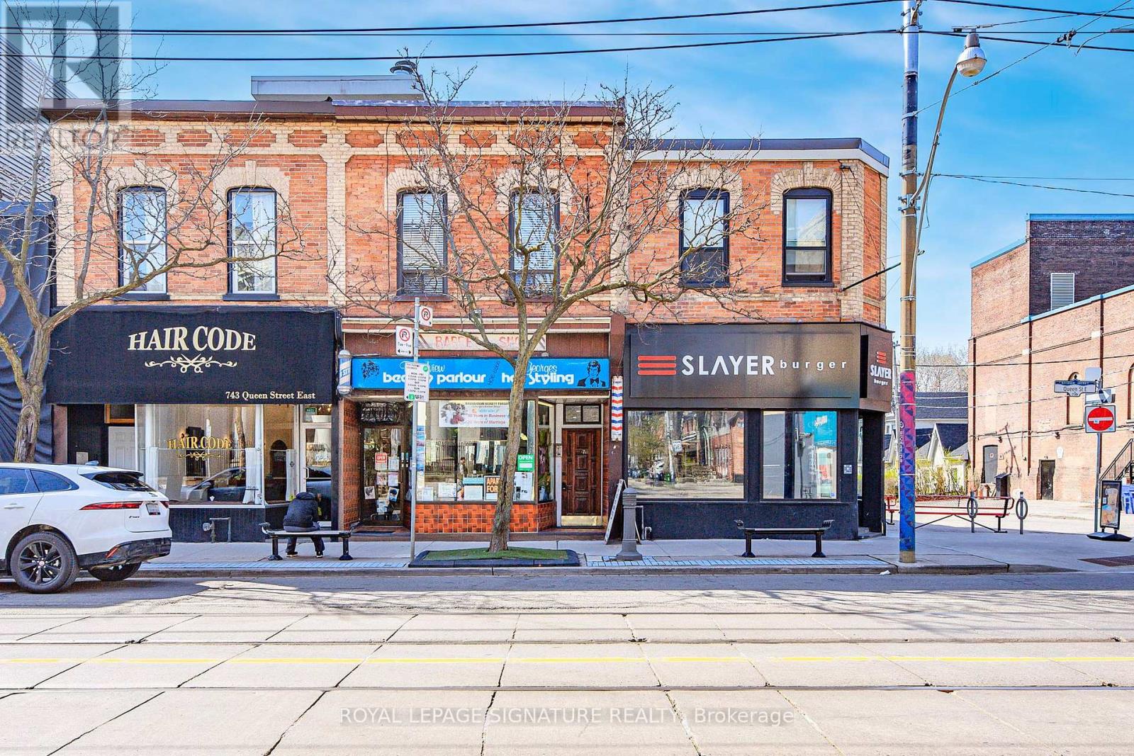 A street view of a building with a sign that says "HAIR CODE" and "SLAYER".