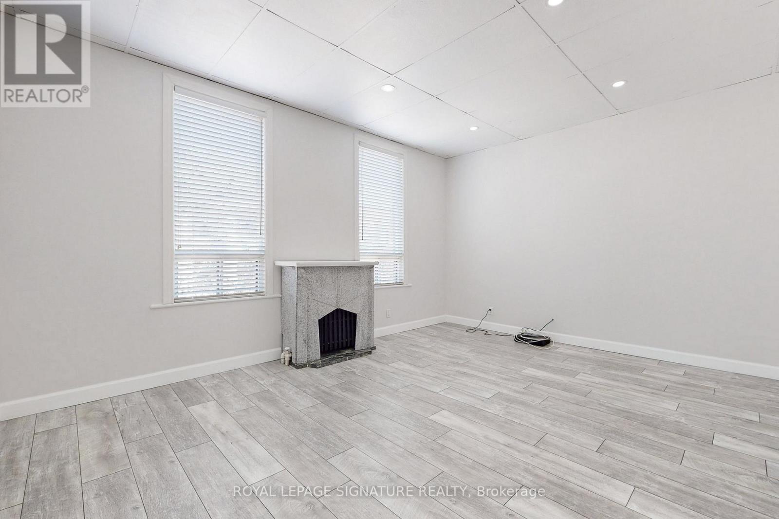 A room with a fireplace and wooden flooring.