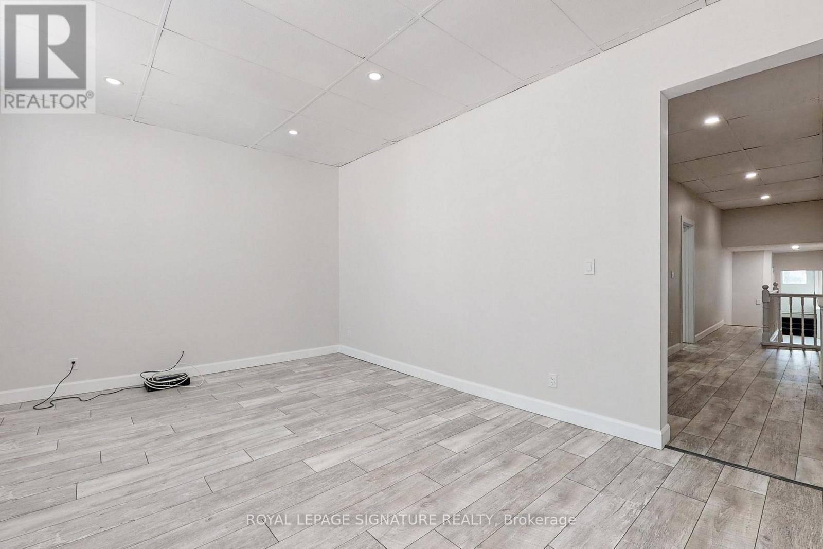 A spacious room with a doorway leading to another room.