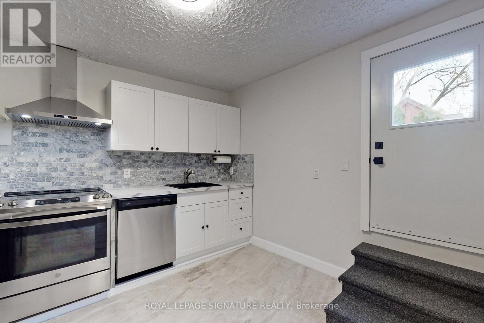 A kitchen with white cabinets and a stainless steel oven.