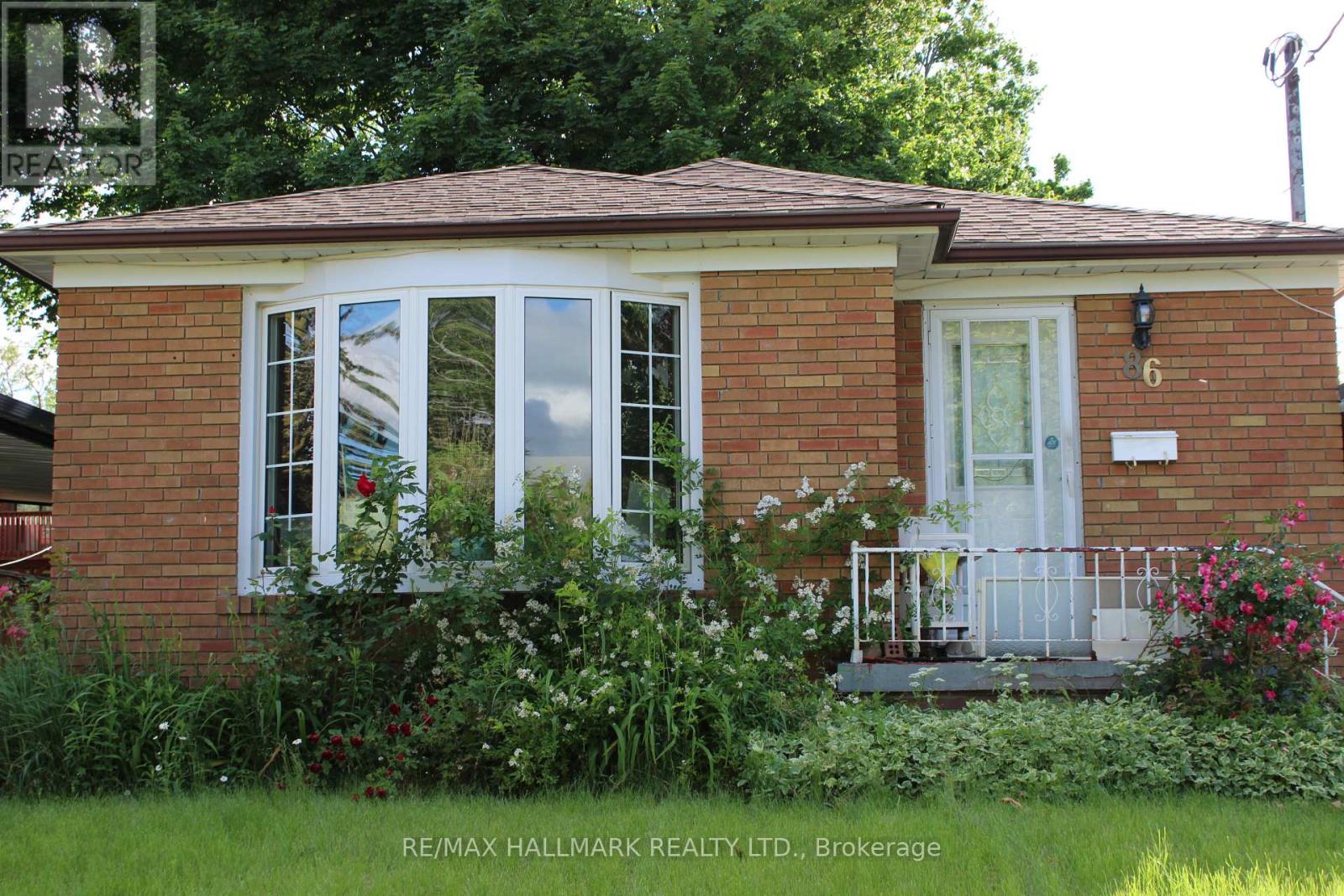 A small red brick house with a white door and windows.