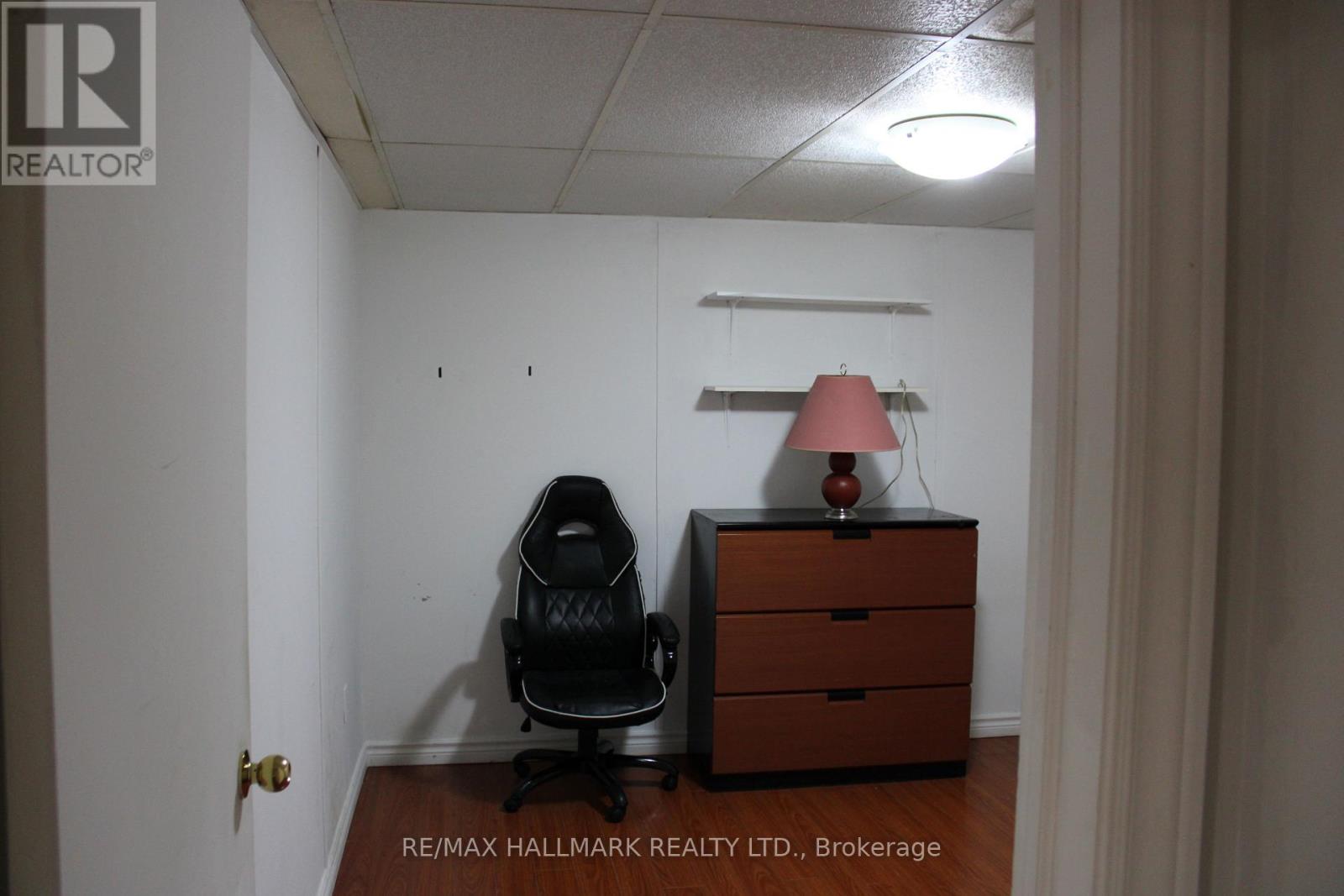 A room with a chair and a desk with a lamp on it.