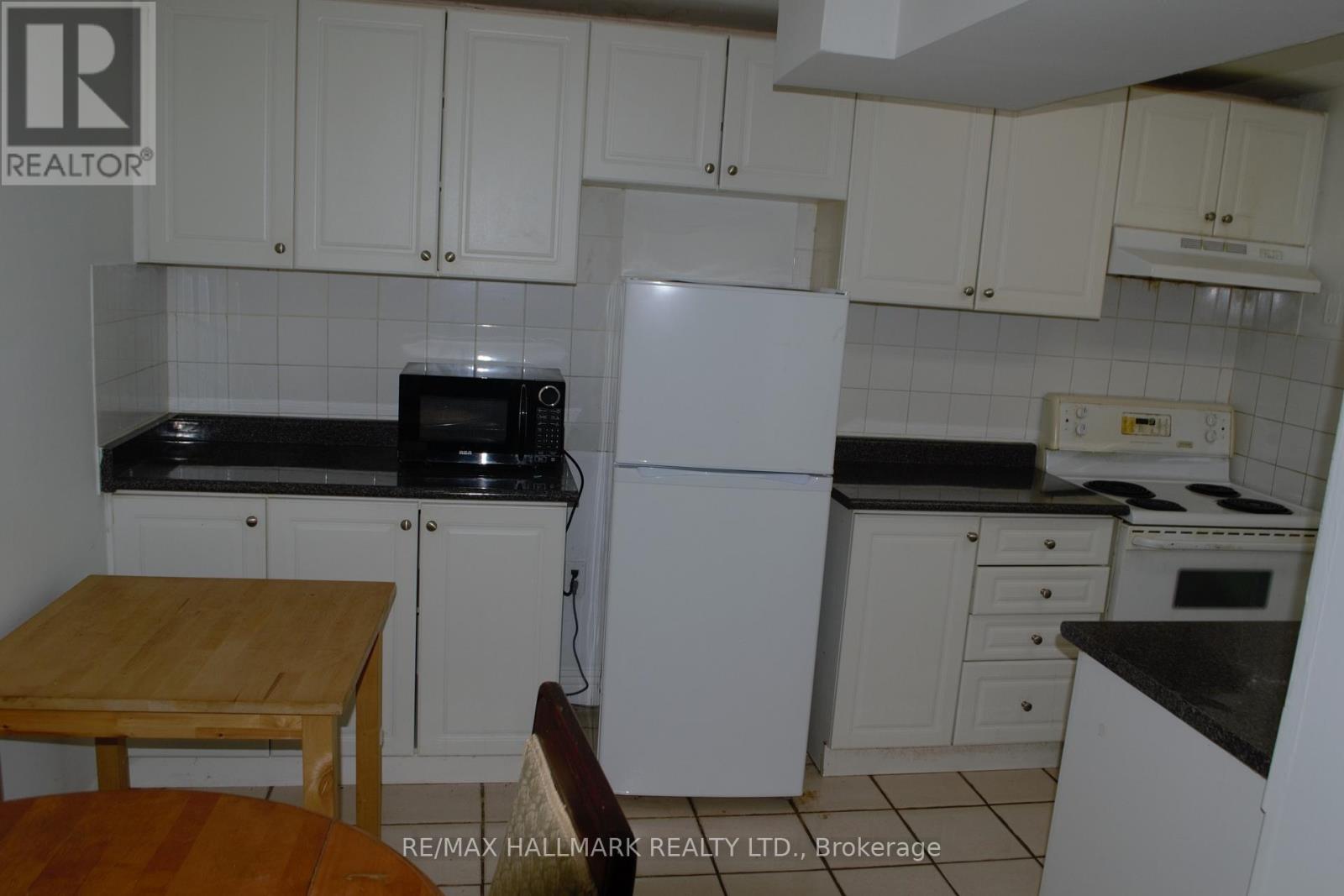 A kitchen with white cabinets and a wooden table.