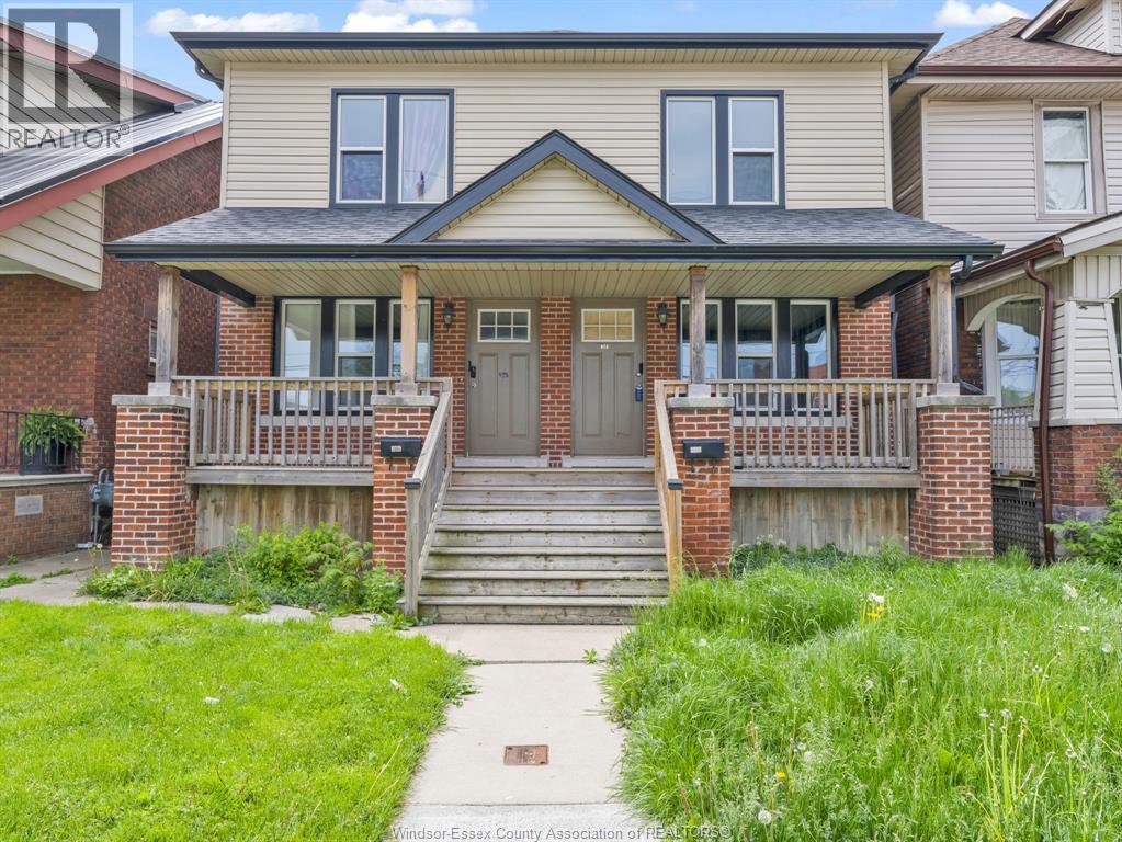 A house with a front porch and a green lawn.