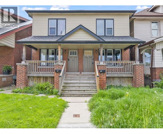 A house with a front porch and a green lawn.