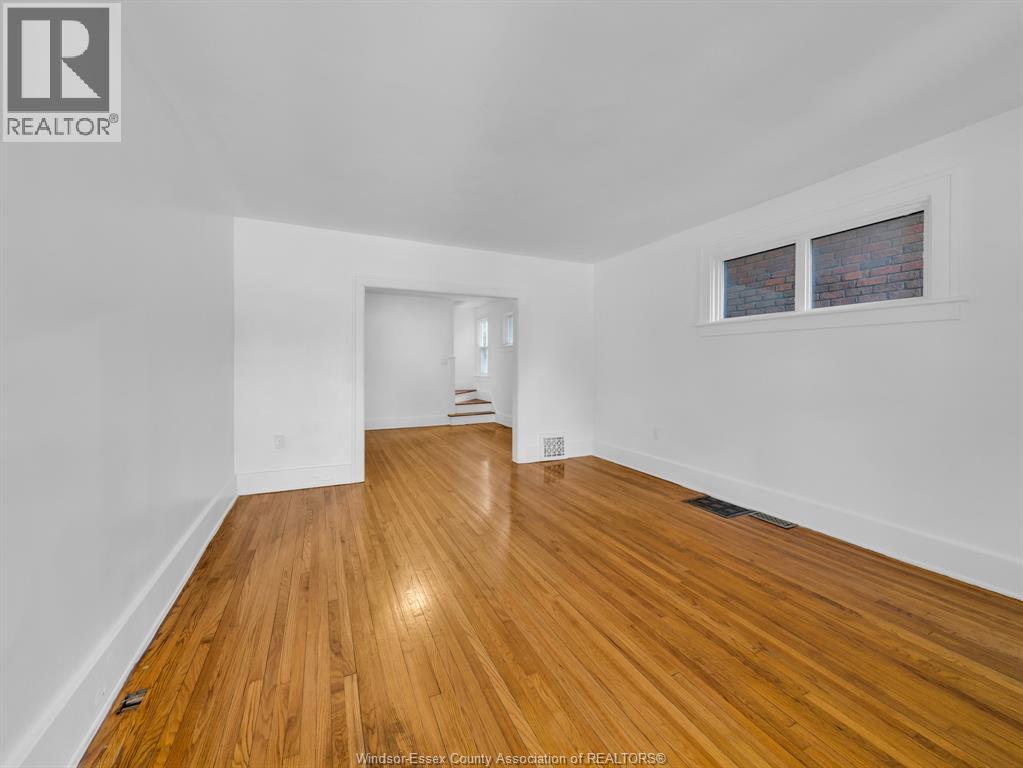 A room with wooden flooring and white walls.