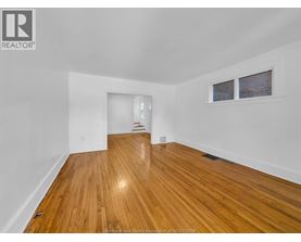 A room with wooden flooring and white walls.