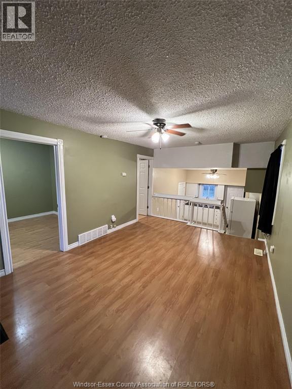 A room with wood flooring and a ceiling fan.