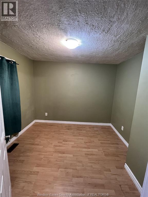 A room with wooden flooring and a ceiling light fixture.