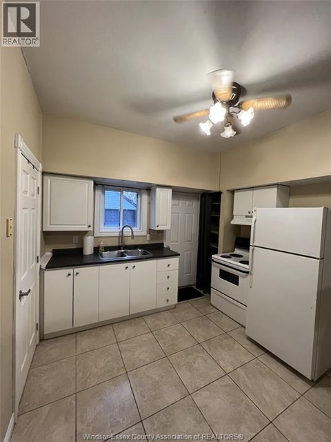 A kitchen with white appliances and cabinets.