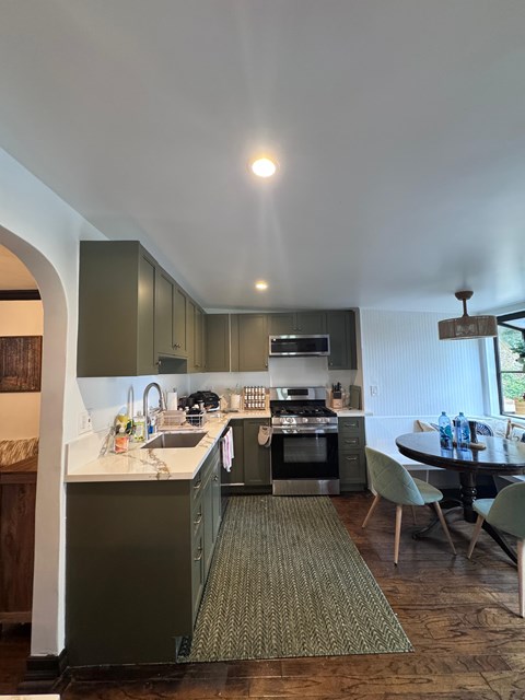 A kitchen with a table and chairs in front of it.