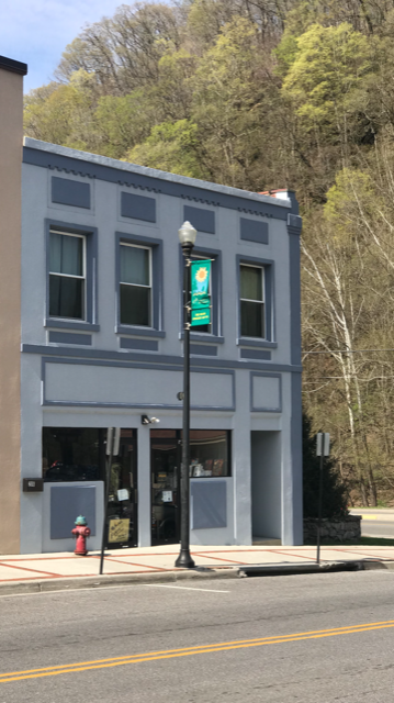 A grey building with a green sign on the front.