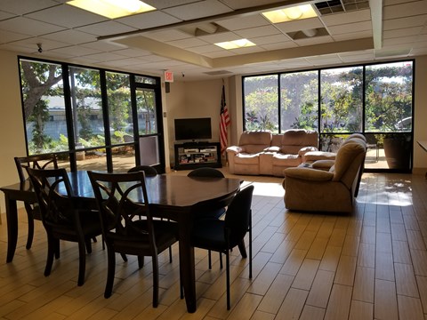 A conference room with a table, chairs, and a television.