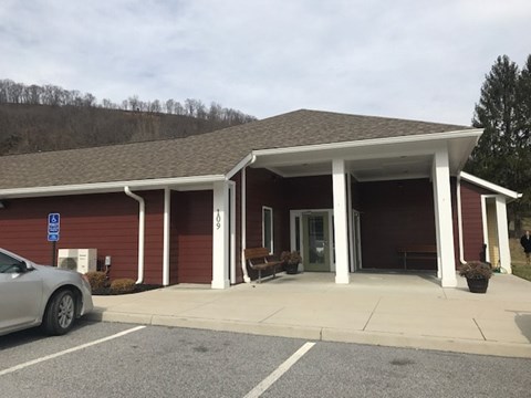 A small building with a car parked in front.