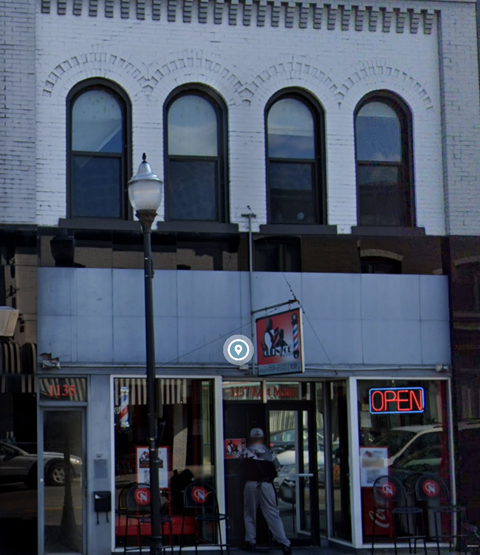 A white building with a red sign that says open.