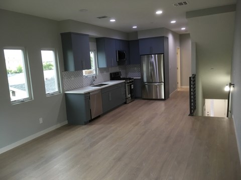 A kitchen with dark wood cabinets and a stainless steel refrigerator.