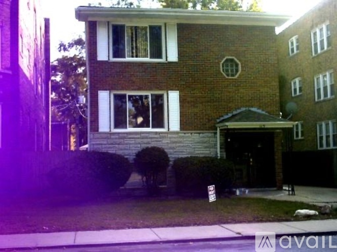 A brick house with a sign in front of it.