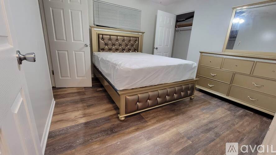 A bedroom with a bed, dresser, and mirror.