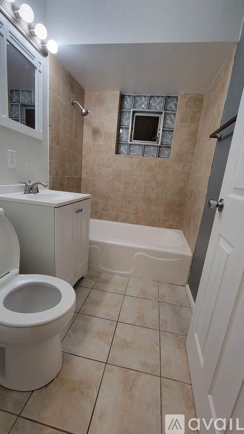 A bathroom with a toilet, sink, and shower area.