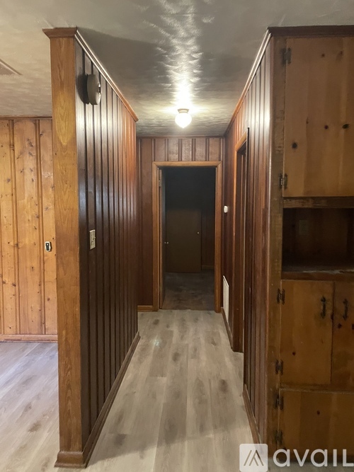 A long hallway with wooden walls and floor.