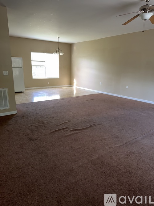 A spacious room with a ceiling fan and a window.