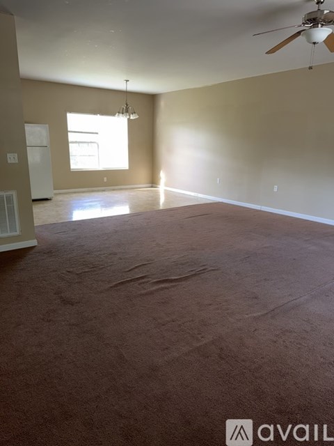 A spacious room with a ceiling fan and a window.