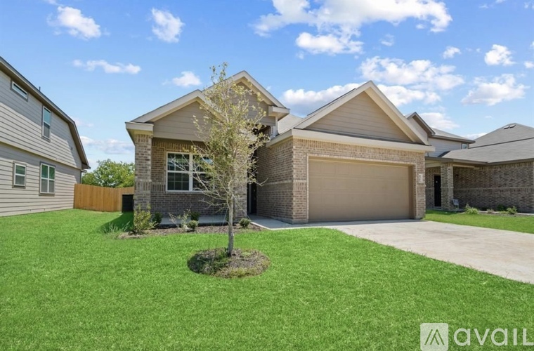 A house with a brown roof and a tree in the front yard.