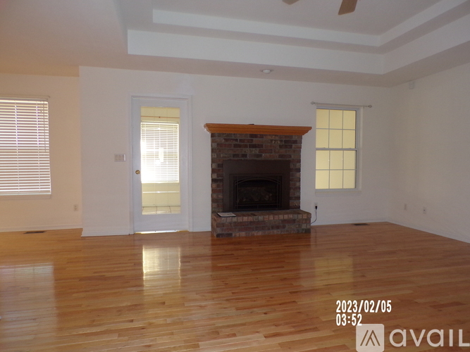 A living room with a fireplace and wooden floors.