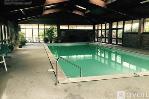A large indoor swimming pool with a metal railing.