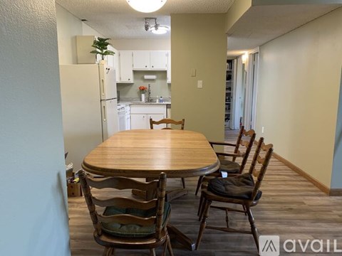 A dining room with a wooden table and chairs.
