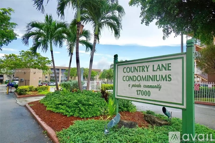 A sign for Country Lane Condominiums stands in front of a landscaped area.