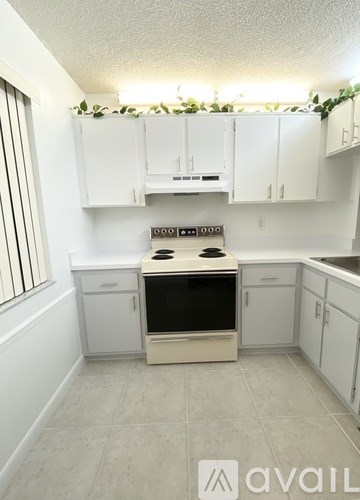 A kitchen with white cabinets and a black stove top oven.