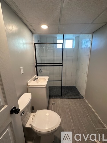 A bathroom with a toilet, sink, and shower.