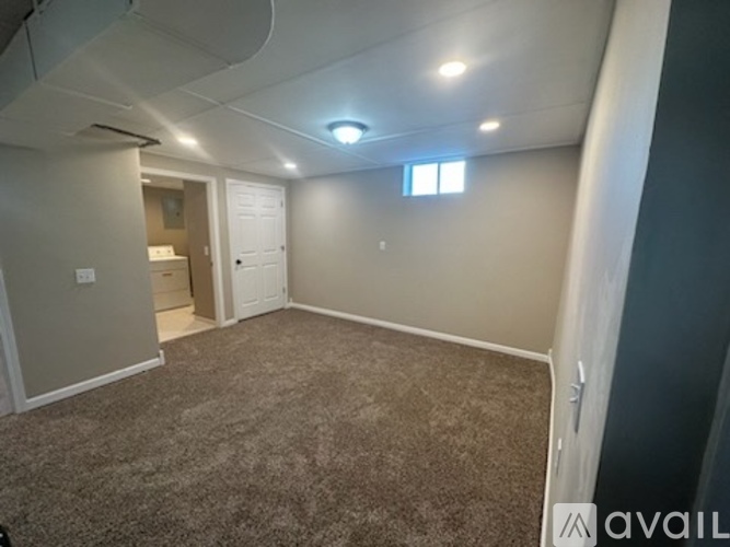 A room with a carpeted floor and a window.