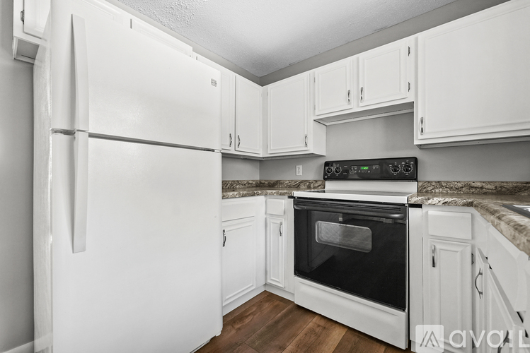 A kitchen with white appliances and cabinets.