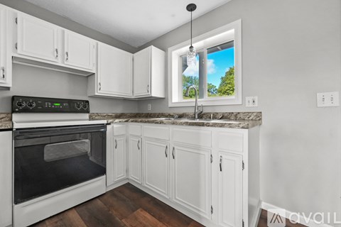 A kitchen with white cabinets and a granite countertop.