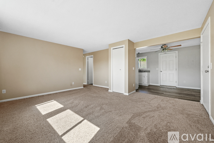 A spacious room with beige walls and a carpeted floor.
