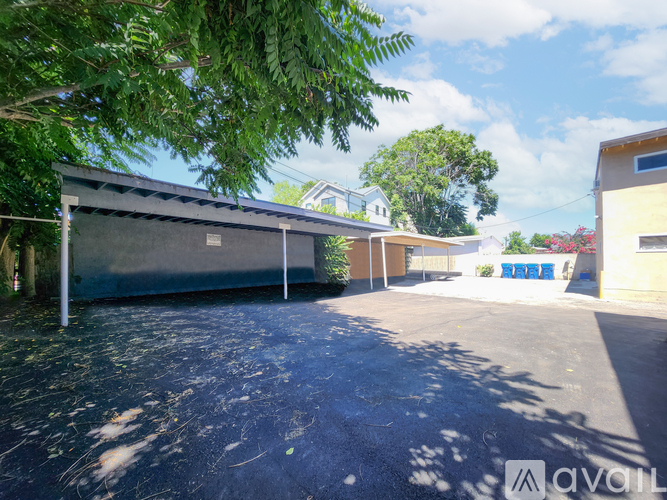 A parking lot with a building and trees in the background.